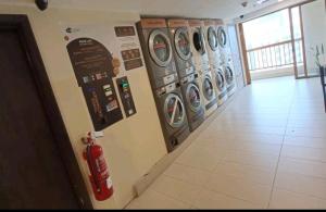 a row of washing machines on a wall with a fire extinguisher at Sunway Resort Suites@Sunway Pyramid and Sunway Lagoon in Kampong Penaga