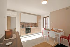 una cucina e una sala da pranzo con tavolo e sedie di La Leonessa - Happy Rentals ad Arco