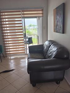 un sofá de cuero negro sentado en una sala de estar en 612 @ Leisure Bay en Pretoria