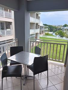 a patio with a table and chairs and a balcony at 612 @ Leisure Bay in Pretoria