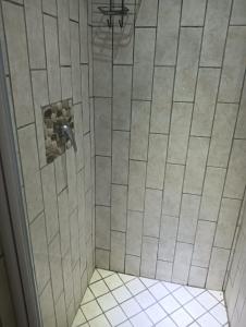 a shower with a glass door with a tile floor at 612 @ Leisure Bay in Pretoria