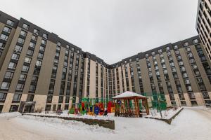 um grande edifício com um parque infantil na neve em Apple em Prigorodnyy