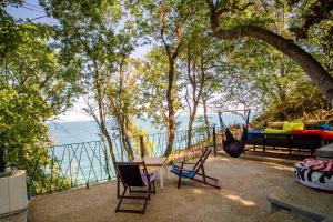 a hammock with a table and chairs and the ocean at Къщички Синьо лято, Черноморец - Варна - Blue Summer Houses Varna in Varna City