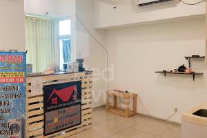 ein Zimmer mit einem Tisch und einem Schild an der Wand in der Unterkunft RedLiving Apartemen TreePark City - Hunian Idamanku Tower Alpine in Kebonnanas