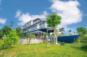 a large house on top of a grass field at DC AROMA VILLA - Venuestay in Hòa Bình