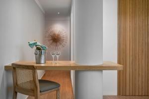 a table with a chair and two wine glasses on it at The Bayou Hotel Langkawi in Pantai Cenang