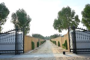 an iron fence with trees on the side of a road at Damas Resort in Mezairaa