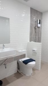 een witte badkamer met een toilet en een wastafel bij ดิ อัยย์ชญา โฮเทล in Ban Phraek Sa