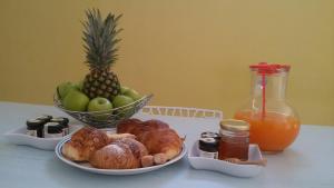 un tavolo con un piatto di prodotti da forno e un cesto di frutta di Def House a Reggio di Calabria