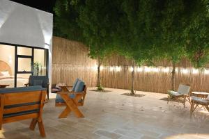 a patio with chairs and tables and a fence at Damas Resort in Mezairaa