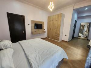 a bedroom with a large white bed and a tv at Light house hotel in Lekki