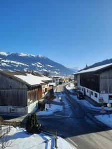 a town in the snow with mountains in the background at Altböckhof in Schlitters