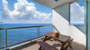 einen Balkon mit einem Tisch und Meerblick in der Unterkunft Buan arco spa pension in Landkreis Buan