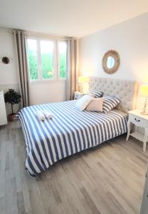 a bedroom with a large bed with blue and white stripes at Bel appartement entre Disney Land et Paris in Chelles