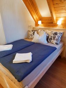 una camera con 2 letti con lenzuola e cuscini blu di Apartman Vitorlás Vendégház a Balatonfüred