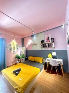 ein Schlafzimmer mit einem gelben Bett und einem Schreibtisch in der Unterkunft Hope homestay - số 2 ngách 60/381 Nguyễn Khang - by Bayhostel in Hanoi