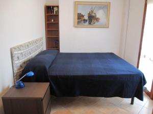 een slaapkamer met een bed met een blauwe deken bij Comfy flat with balcony at 30metres from the beach in Lido