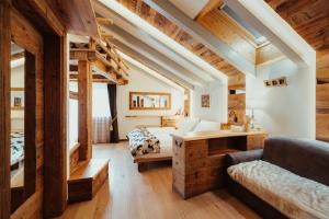 a bedroom with a loft bed and a desk at Hotel Alpenrose in Arabba