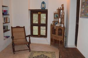 sala de estar con silla y ventana en Ella's Swahili House, en Bagamoyo