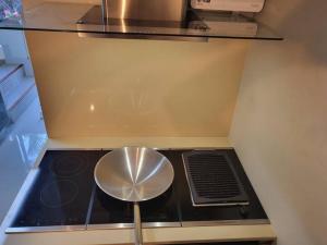 a stove top in a kitchen with a stool at Brianna Balcony Apartment in Ban Ton Chok