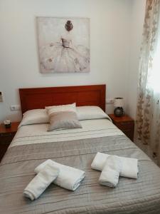コニル・デ・ラ・フロンテーラにあるApartamento Sebastián Solo Familiasのベッドルーム1室(ベッド1台、タオル2枚付)