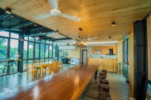 an open kitchen and dining room with a large wooden table at DC AROMA VILLA - Venuestay in Hòa Bình