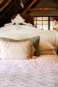 a white bed with a white headboard and pillows at Cape Dutch @ Keerweder in Franschhoek