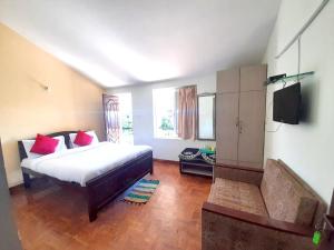 sypialnia z łóżkiem i telewizorem z płaskim ekranem w obiekcie A2 Home Stay w mieście Kodaikānāl