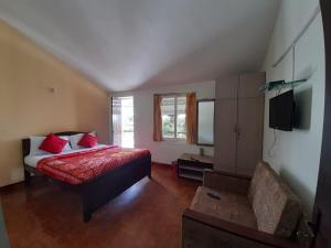 sypialnia z łóżkiem i kanapą w obiekcie A2 Home Stay w mieście Kodaikānāl