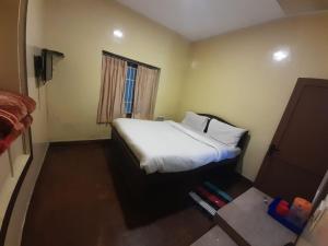 sypialnia z białym łóżkiem i oknem w obiekcie A2 Home Stay w mieście Kodaikānāl