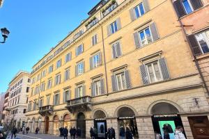 un grand bâtiment avec des personnes qui marchent devant lui dans l'établissement Piazza di Spagna Apartment, à Rome