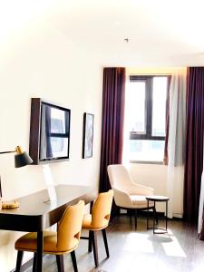 una camera d'albergo con scrivania, sedie e tavolo di Duas House #S2 Sapphire Hạ Long Căn studio view thành phố a Ha Long