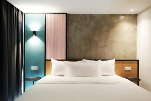 a bedroom with a large bed with white sheets at The Bayou Hotel Langkawi in Pantai Cenang