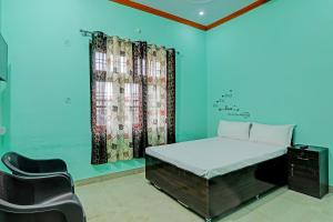 a bedroom with a bed and a chair in it at OYO Royal inn homestay in Lucknow