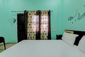 a bedroom with a large white bed with a window at OYO Royal inn homestay in Lucknow