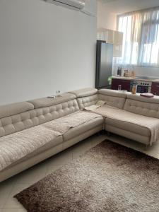 a white couch in a living room with a kitchen at Mezes fushe Kashar in Tirana