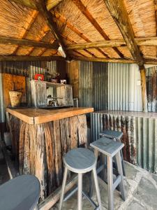 a kitchen with two stools and a counter with a microwave at Tafeni Farm Cottages in Swartberg