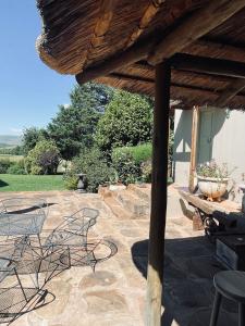 a patio with chairs and a table and a grill at Tafeni Farm Cottages in Swartberg