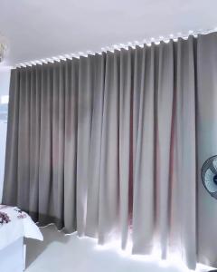 a curtain on a window in a bedroom at Condo Home in Puerto Princesa near PPS Airport in Puerto Princesa City