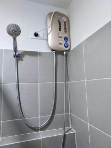 een douche in een badkamer met een douchekop bij Condo Home in Puerto Princesa near PPS Airport in Puerto Princesa City