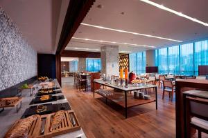 a restaurant with tables and chairs in a room at AC Hotel by Marriott Santa Fe in Mexico City