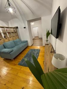 a living room with a blue couch and a flat screen tv at Lucasi apartament in Sibiu