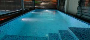 a swimming pool with blue water in a building at Altitude Villa A Serene Retreat Panchgani in Panchgani