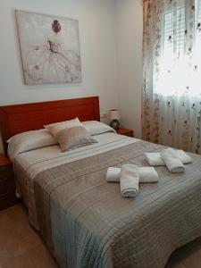 コニル・デ・ラ・フロンテーラにあるApartamento Sebastián Solo Familiasのベッドルーム1室(大型ベッド1台、タオル付)