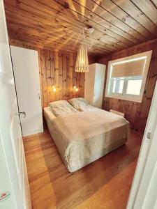a bedroom with a bed and a wooden ceiling at Gausta Lodge med 6 sengeplasser i nærhet til Gaustatoppen in Gaustablikk