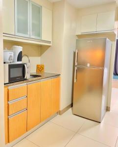 a kitchen with a stainless steel refrigerator and cabinets at Thompson Suites - 2 beds, One Uptown Residences 28F A - XBOX & Netflix in Manila
