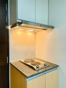 a kitchen with a stove top on a counter at Thompson Suites - 2 beds, One Uptown Residences 28F A - XBOX & Netflix in Manila