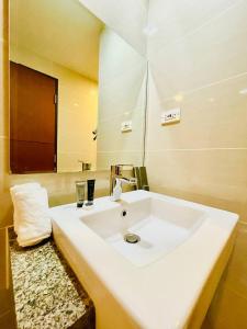 a bathroom with a white sink and a mirror at Thompson Suites - 2 beds, One Uptown Residences 28F A - XBOX & Netflix in Manila