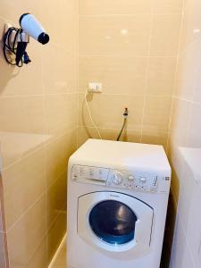 a washing machine in a corner of a bathroom at Thompson Suites - 2 beds, One Uptown Residences 28F A - XBOX & Netflix in Manila