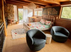 a living room with a bed and two chairs at The Enchanted Stone Cottage in Margaret River Town